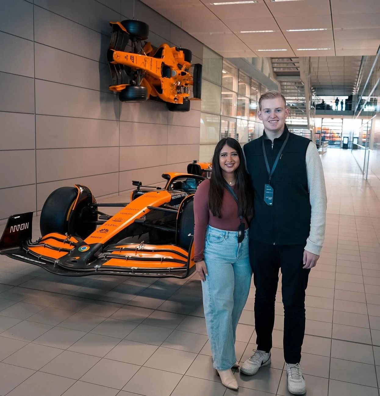 Allison and Daniel beside a McLaren Formula 1 car at the team's headquarters
